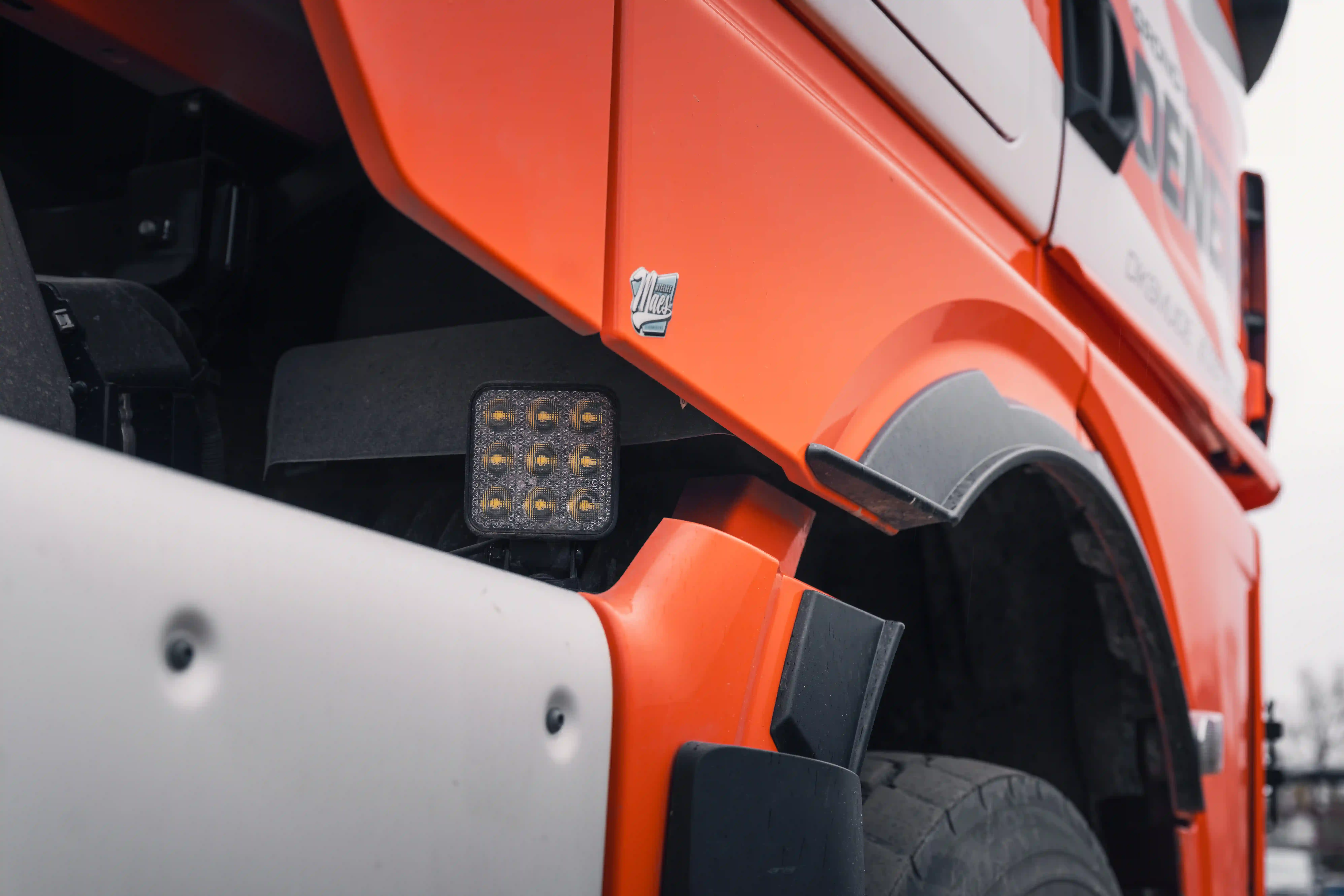 Iveco fellivagn á framkvæmdasvæði með gult varnarljós kveikt við rökkur